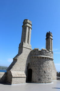 Low angle view of historic building against blue sky