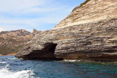 Rock formation in sea against sky