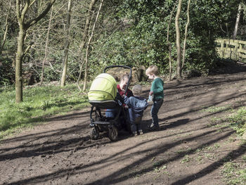 Rear view of people walking on road in forest