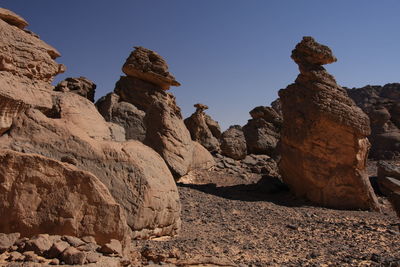 Scenic view of rocky mountains against clear sky acacus moutain, libya