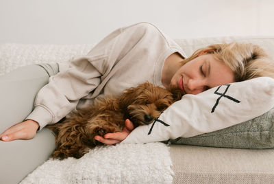 Midsection of a dog sleeping on bed at home