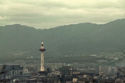 Buildings in city against cloudy sky