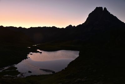 Scenic view of silhouette mountains against sky at sunset