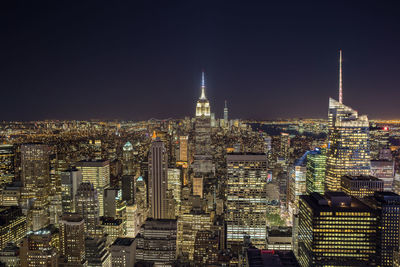 Illuminated cityscape against sky at night