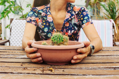 Midsection of woman holding potted plant