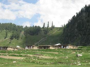 Scenic view of grassy field against cloudy sky