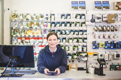 Portrait of smiling mature saleswoman working in computer store