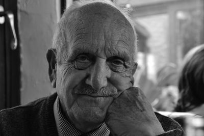 Close-up portrait of senior man with 89hand on chin