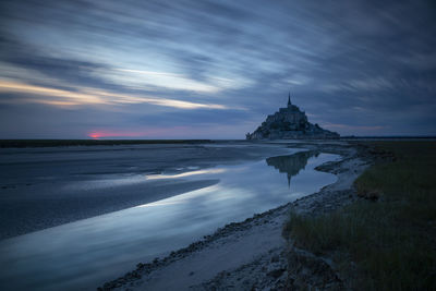 Scenic view of sea by building against sky during sunset