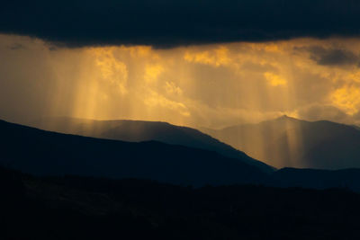 Scenic view of silhouette mountains against sky at sunset