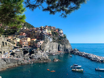 Panoramic view of sea and buildings against clear blue sky