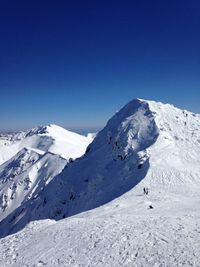 Scenic view of snowcapped mountains against blue sky