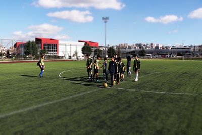 People playing soccer against sky