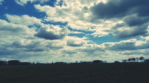 Scenic view of field against cloudy sky