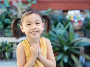 Positive charming 4 years old cute baby asian girl, little child with adorable pigtails hair smiling