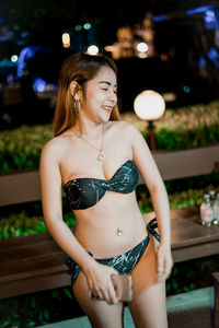 Portrait of young woman standing in park