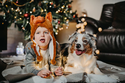 Dogs sitting on christmas tree at home
