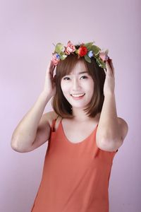 Portrait of smiling young woman against white background