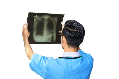 Rear view of man photographing against white background