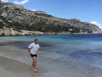 Full length of boy on beach against sky