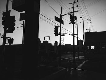 Low angle view of silhouette electricity pylon against sky