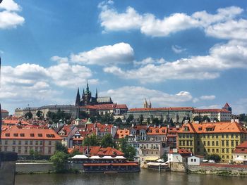 Townscape by river against sky