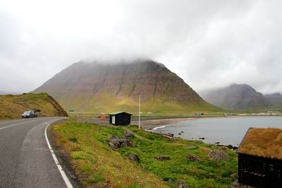 Road by mountain against sky