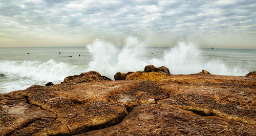 Panoramic shot of rocks on beach against sky