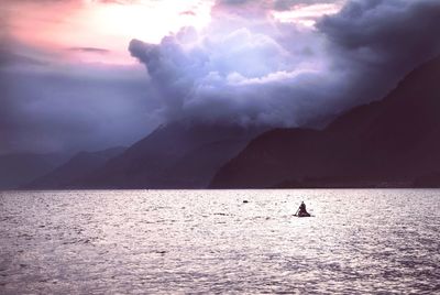 Silhouette man in sea against sky