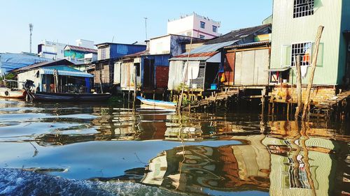 Boats moored by houses against clear sky