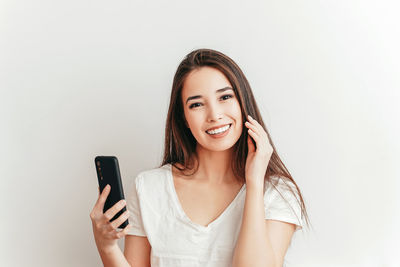 Portrait of a smiling young woman using mobile phone