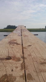 Surface level of pier on lake against sky