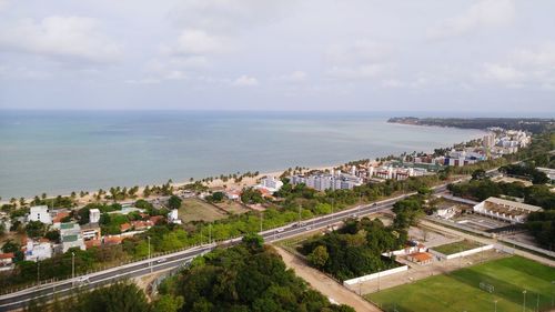 Houses by sea against sky