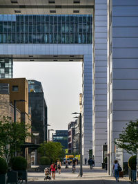 People on road against buildings in city