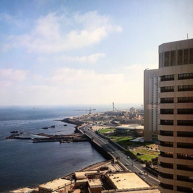 architecture, building exterior, sea, built structure, water, sky, horizon over water, city, high angle view, beach, cloud - sky, residential building, cityscape, residential structure, day, outdoors, residential district, shore, cloud, building