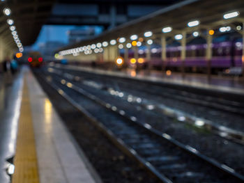 Train at railroad station platform at night