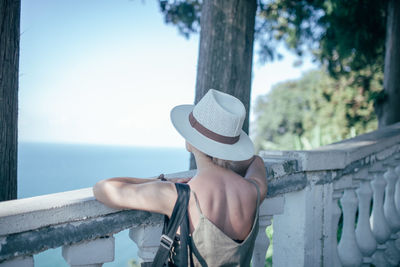 Rear view of woman in hat looking at sea