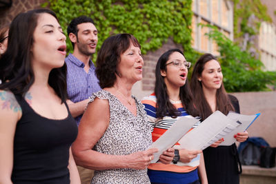 Multi-ethnic choir singers performing outside language school