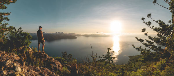 Man looking at sea against sky during sunset