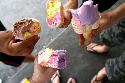 Low section of men holding ice cream cones
