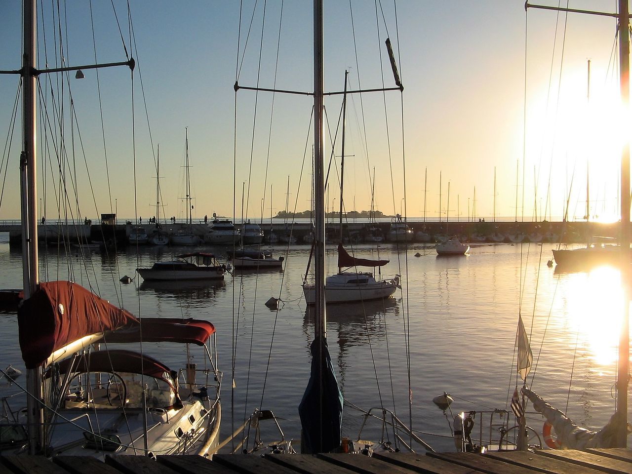 SAILBOATS AT HARBOR AGAINST SKY DURING SUNSET