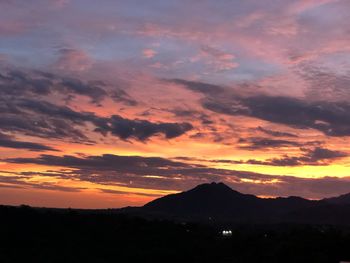 Scenic view of silhouette mountains against romantic sky at sunset