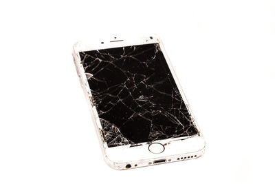 Close-up of broken smart phone against white background