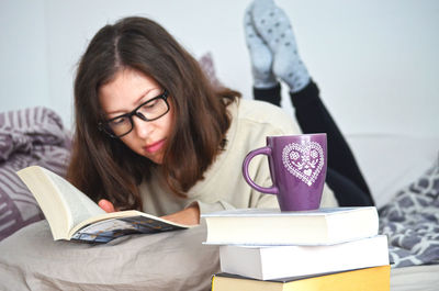 Portrait of young woman reading book