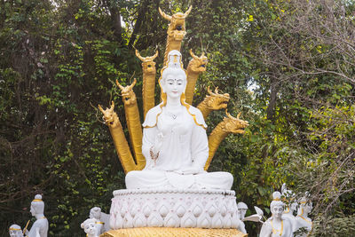 Statue of buddha against trees