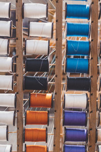 Close-up of multi colored thread spools on loom in factory