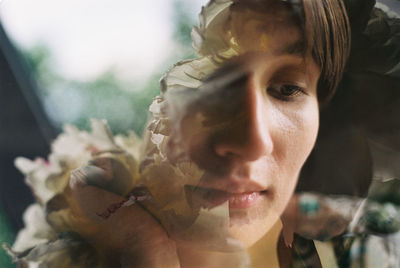 Double exposure of thoughtful young woman and flowers