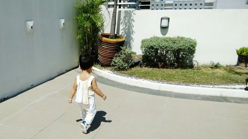 Full length of woman walking against built structure