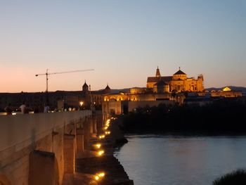 View of illuminated buildings against sky at sunset