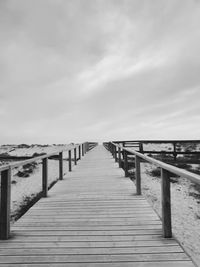 Wooden pier over sea against sky